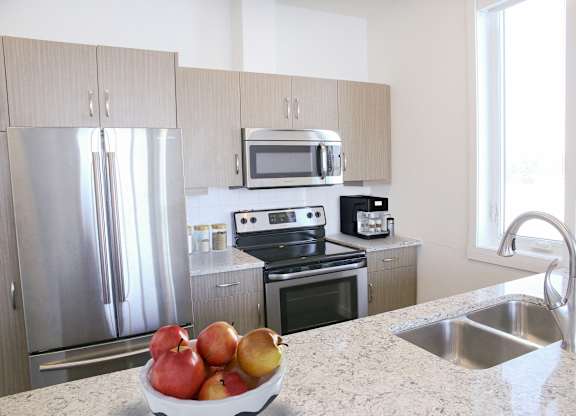 A kitchen with a bowl of fruit on the counter.