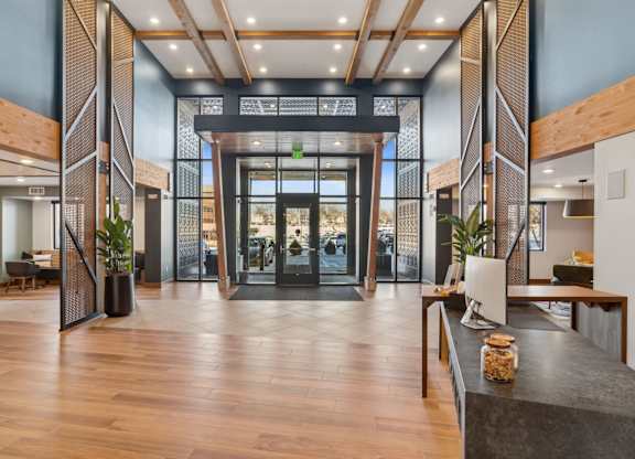 A modern lobby with wood floors and a glass wall.