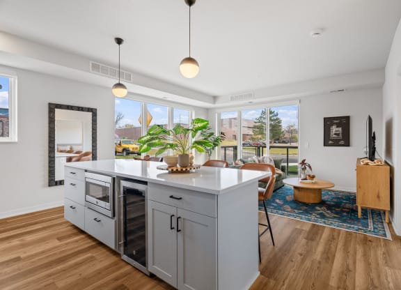 an open kitchen with a large island and a living room with a table and chairs