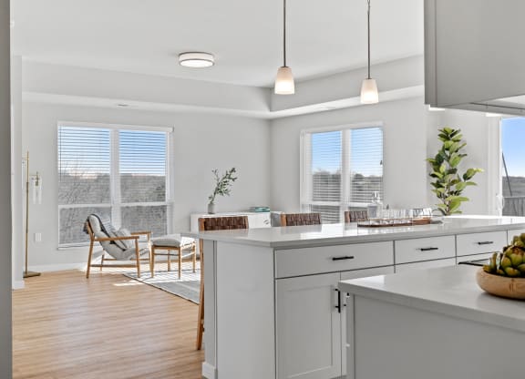 an open kitchen and dining room with white cabinets and white counter tops