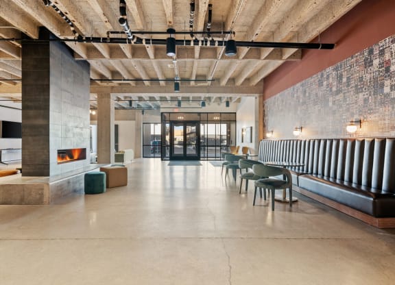 the lobby of a building with a fireplace and tables and chairs
