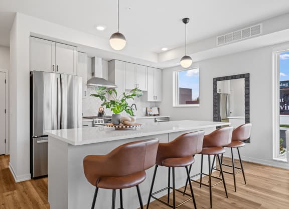 a kitchen with a large island with bar stools