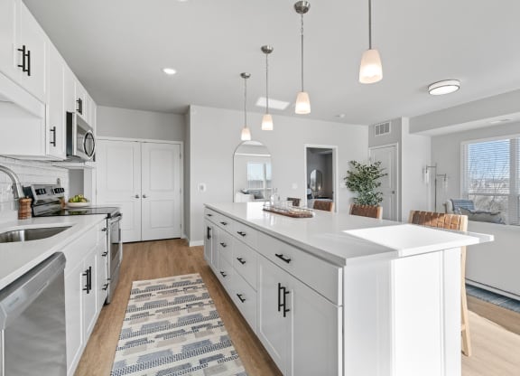 a large kitchen with white cabinets and a large island