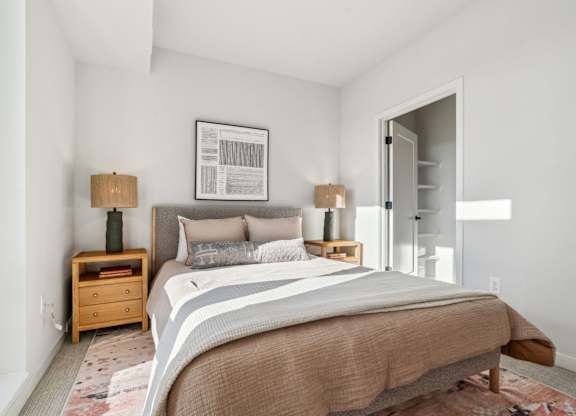 A bedroom with a large bed and a wooden nightstand.