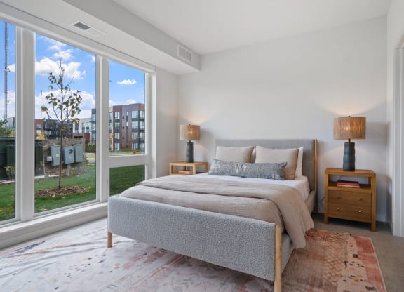 a bedroom with a bed and a large window