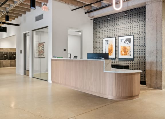 a lobby with a reception desk and a glass door