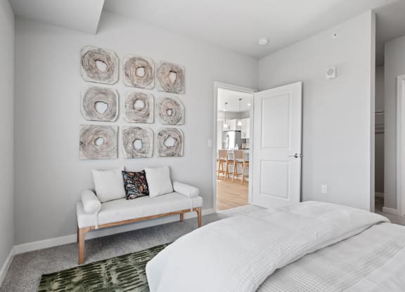 a white bedroom with a bed and a couch