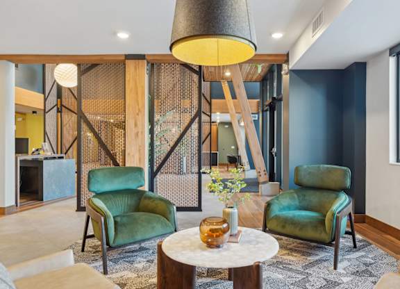 A modern living room with a wooden partition and green chairs.