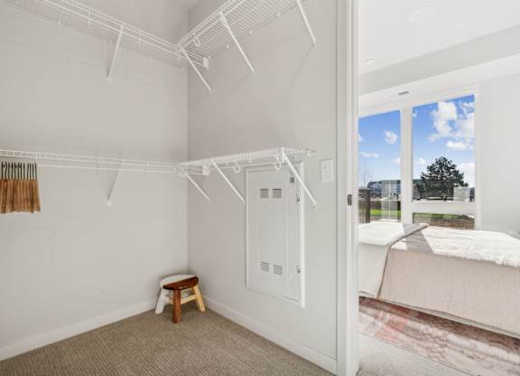 A white bedroom with a bed and a small table.