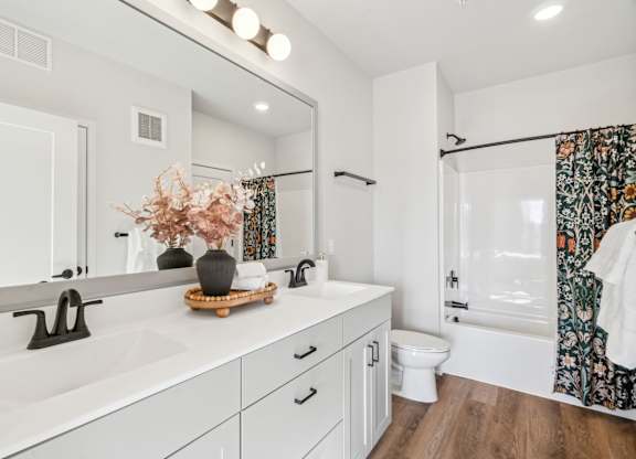 A white bathroom with a wooden tray on the sink.