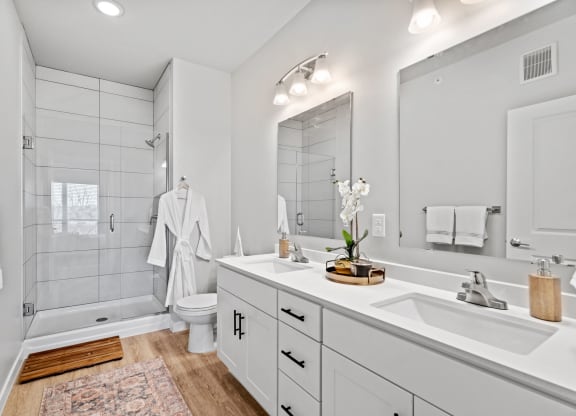 a white bathroom with a large mirror and a sink