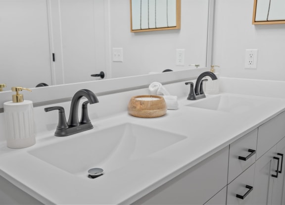 a white bathroom with two sinks and a mirror