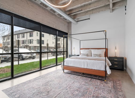 a bedroom with a bed and a large window