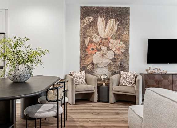 A living room with a large floral tapestry on the wall and a variety of seating options.