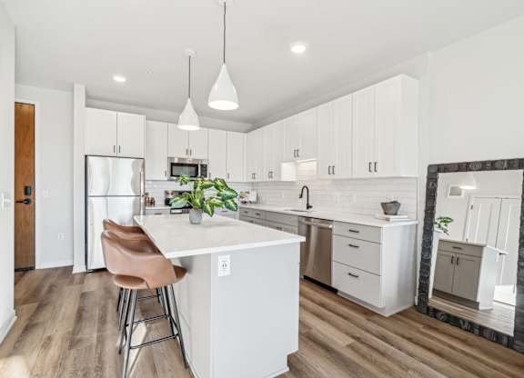 A kitchen with a white island and a refrigerator.