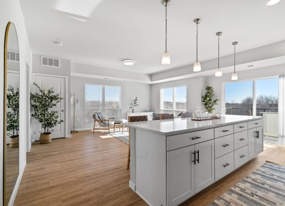 an open kitchen and living room with white cabinets and a large island