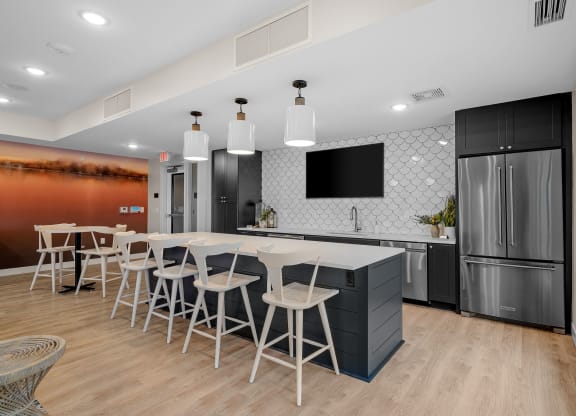 a kitchen with a table and chairs in front of a refrigerator