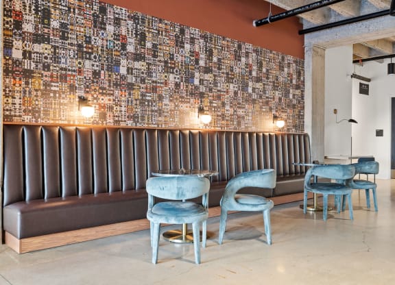 a seating area with blue chairs and a wall covered in graffiti