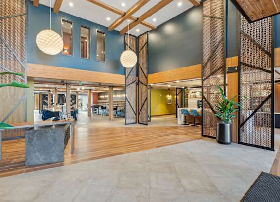 A modern interior with wooden floors and a mix of seating areas.