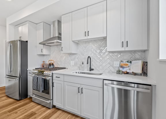 a kitchen with white cabinets and stainless steel appliances