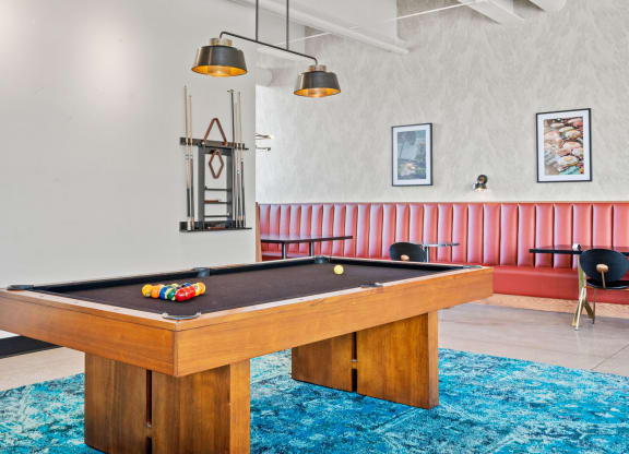 a pool table in a living room with a blue rug