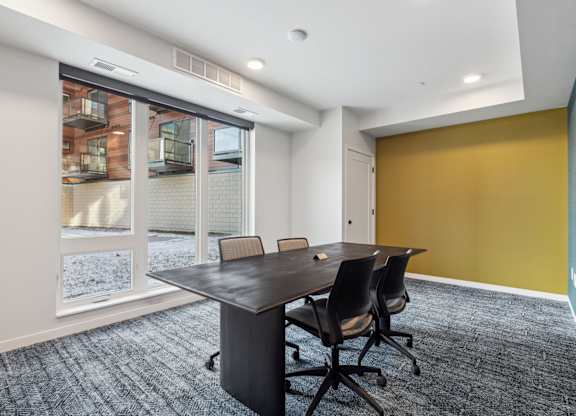 A conference room with a table and chairs.