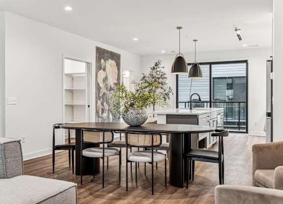 A modern dining room with a black table and chairs.