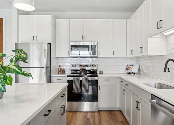 A modern kitchen with white cabinets and stainless steel appliances.