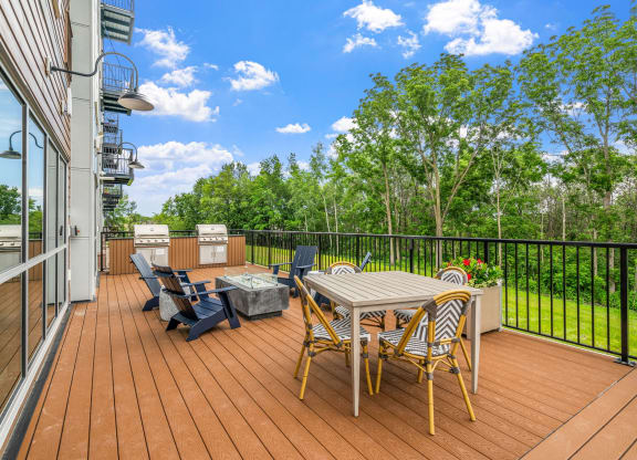 a patio with a table and chairs on a deck