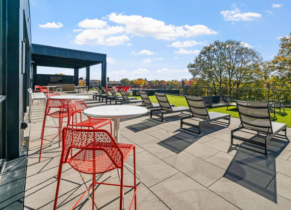 a patio with tables and chairs on a roof top patio
