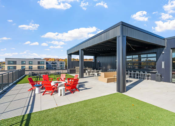 the outdoor patio of a building with red chairs and a patio