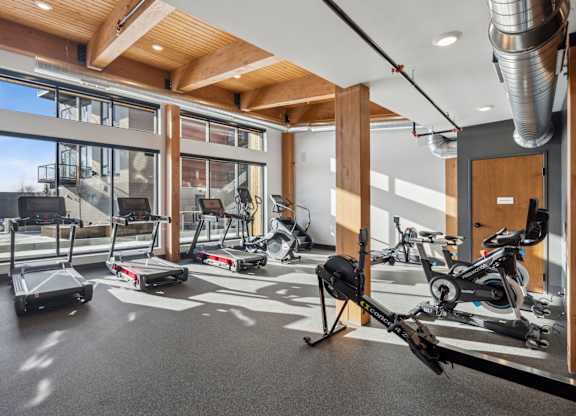 A gym with treadmills, exercise bikes and a rowing machine.