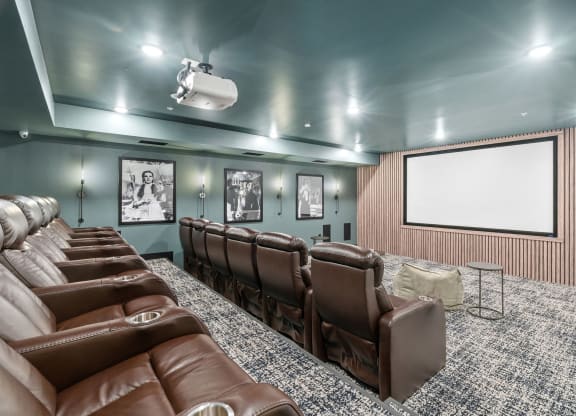 a large screening room with leather chairs and a projector screen