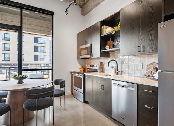 A modern kitchen with a large island and stainless steel appliances.