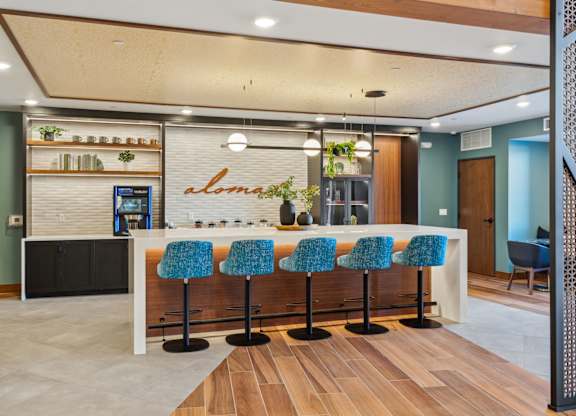 A bar area with blue chairs and a counter.