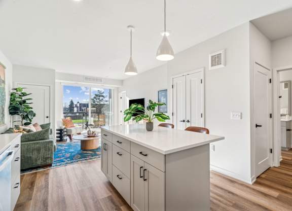 A kitchen with a large island and pendant lights.