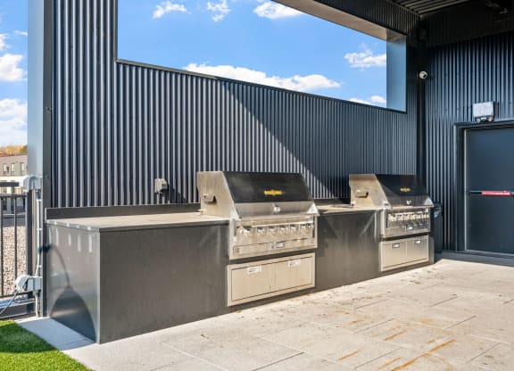 the outdoor kitchen has stainless steel appliances and a large window