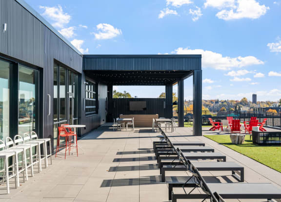 an outdoor patio with tables and chairs and a black building