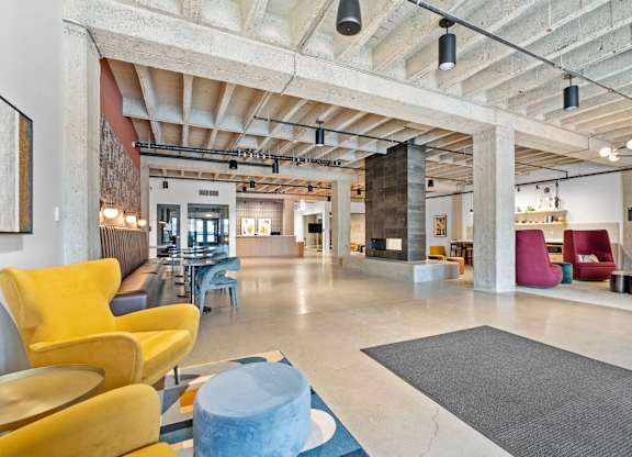 A large open space with a yellow chair and a blue table.