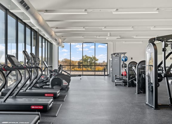 a gym with cardio equipment and a view of the outdoors