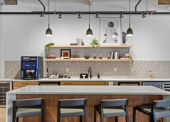 A modern kitchen with a bar area and four chairs.
