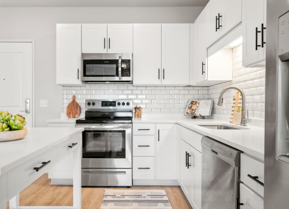 a kitchen with white cabinets and stainless steel appliances
