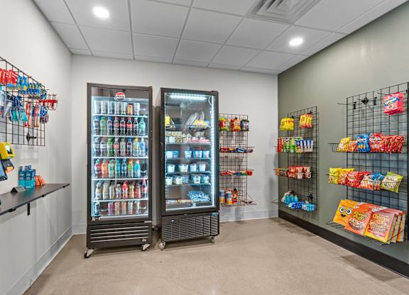 A display of snacks and drinks in a cooler and shelves.
