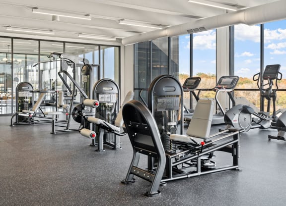 a gym with cardio equipment and windows in a building
