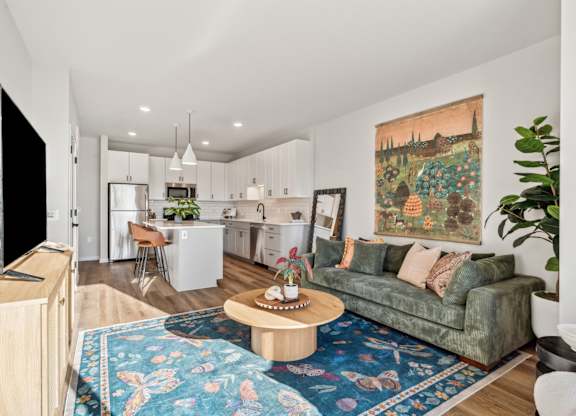 A living room with a couch, a coffee table, and a television.