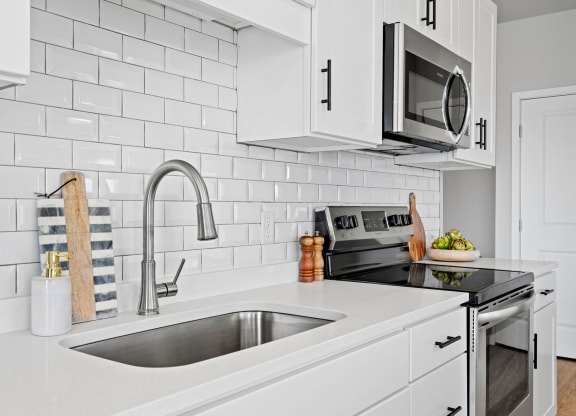 a white kitchen with a sink and a microwave