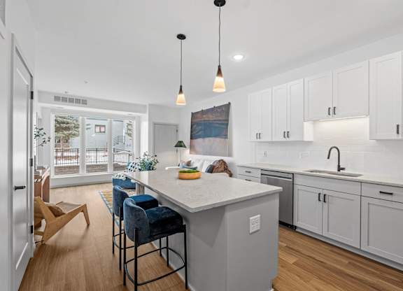 A kitchen with a white countertop and blue chairs.