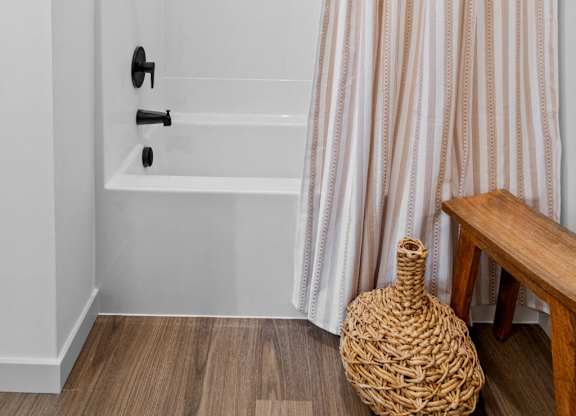 A white bathroom with a striped shower curtain.