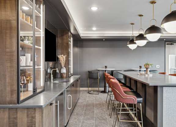 A modern kitchen with a bar area and seating.