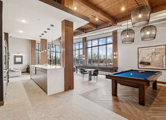 A room with a pool table and a large window.